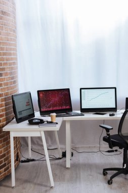 Bilgisayarlar dijital tabletin yakınındaki monitörlerde finans çizelgelerine sahipler, kahve içmek için ofisteki masaya telefon ediyorlar. 