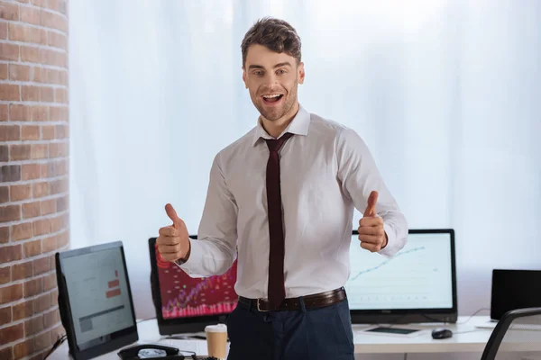 Fröhlicher Geschäftsmann Zeigt Geste Mit Computern Auf Verschwommenem Hintergrund — Stockfoto