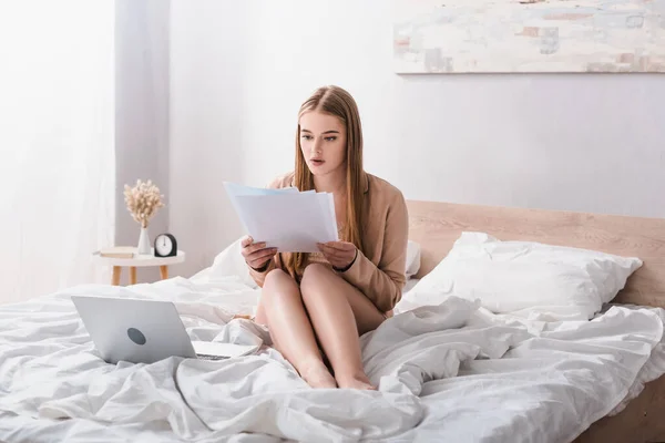 Freelance Accappatoio Seta Guardando Documenti Vicino Computer Portatile Letto — Foto Stock