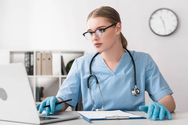 Veterinario Joven Gafas Guantes Látex Utilizando Portátil Cerca Del Portapapeles — Foto de Stock