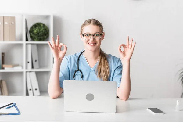 Veterinario Alegre Gafas Mostrando Signo Cerca Gadgets Escritorio — Foto de Stock