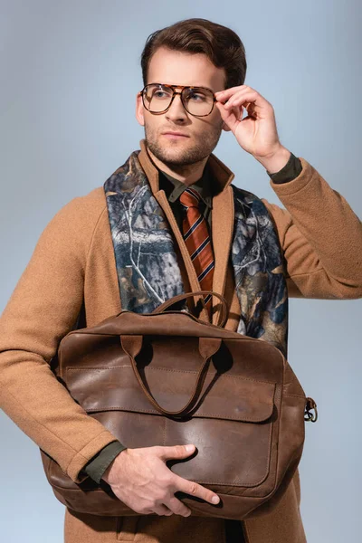 Homem Elegante Casaco Inverno Ajustando Óculos Enquanto Segurando Saco Marrom — Fotografia de Stock