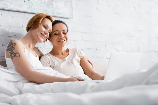 Happy Interracial Lesbian Couple Watching Movie Laptop Bed Blurred Foreground — Stock Photo, Image