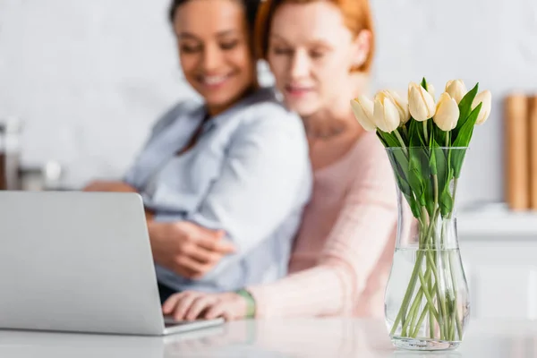 Fuoco Selettivo Vaso Con Tulipani Vicino Felice Coppia Interrazziale Lesbica — Foto Stock