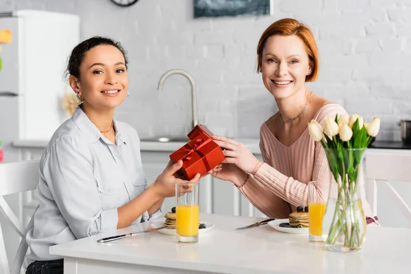 Happy Interracial Lesbian Couple Looking Camera While Holding Gifts Breakfast — Stock Photo, Image