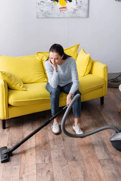 Dona Casa Cansada Sentado Sofá Amarelo Perto Aspirador — Fotografia de Stock