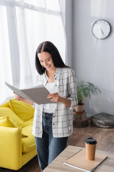 Freelancer Sonriente Mirando Documentos Carpeta Papel Cerca Café Para Mesa — Foto de Stock