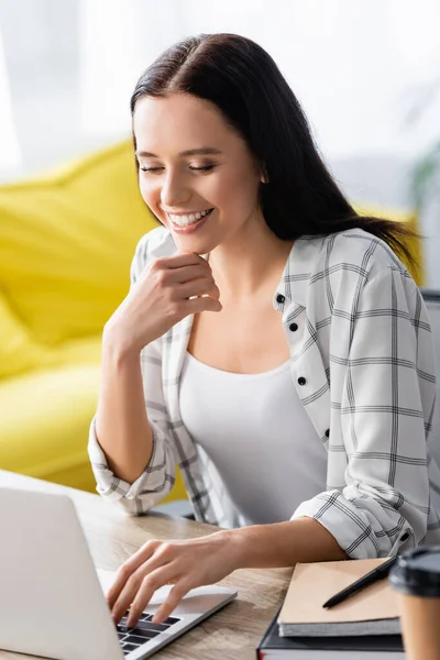 Freelancer Alegre Digitando Laptop Perto Notebooks Primeiro Plano Desfocado — Fotografia de Stock