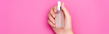 cropped view of woman with bottle of cuticle remover on pink background, banner clipart