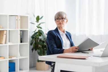Belgeli gözlüklü orta yaşlı takım lideri. 