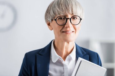 Gözlüklü ve takım elbiseli mutlu orta yaşlı takım lideri