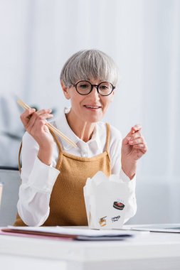 Kutunun içinde yemek artıklarının yanında gözlüklü, mutlu bir takım lideri.