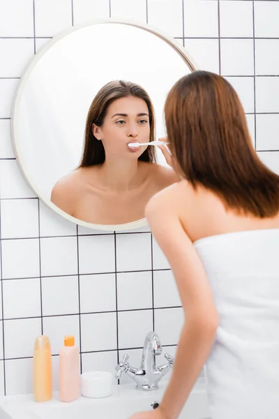 Giovane Donna Lavarsi Denti Mentre Guarda Nello Specchio Bagno — Foto Stock