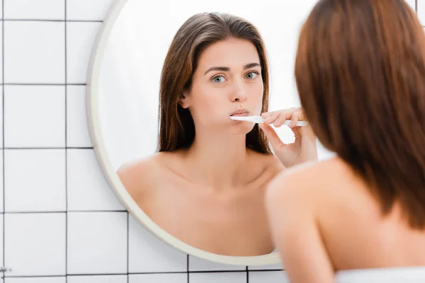 Young Woman Brushing Teeth Mirror Bathroom Blurred Foreground — Stock Photo, Image