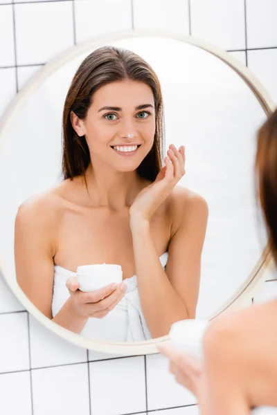 Happy Woman Smiling While Applying Face Cream Mirror Bathroom Blurred — Stock Photo, Image