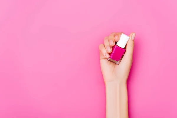 Ovanifrån Preparerad Kvinnlig Hand Med Flaska Glänsande Nagellack Rosa Bakgrund — Stockfoto