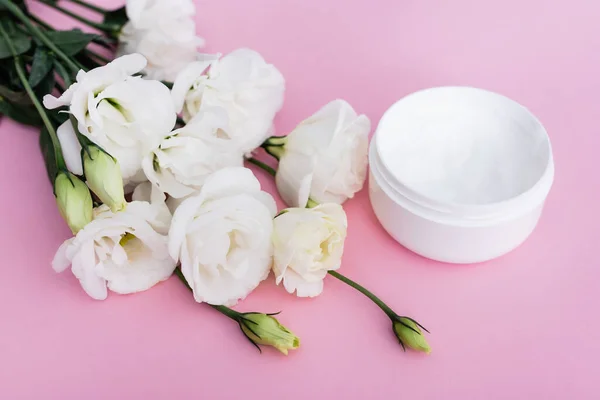Pembe Arka Planda Beyaz Eustoma Çiçekleri Kozmetik Krem — Stok fotoğraf