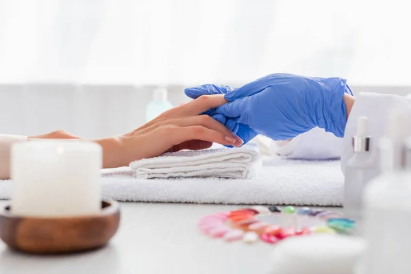 Partial View Manicurist Latex Gloves Touching Hand Client Blurred Foreground — Stock Photo, Image