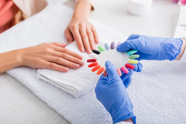 Partial View Manicurist Showing Palette Fake Nails Client Blurred Background — Stock Photo, Image