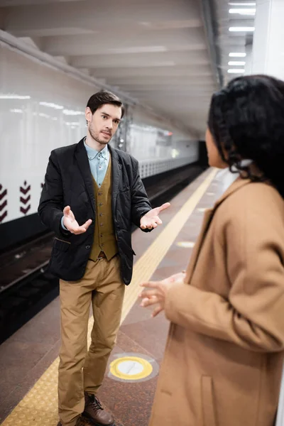 Mann Gestikuliert Gespräch Mit Afrikanisch Amerikanischer Frau Auf Verschwommenem Hintergrund — Stockfoto