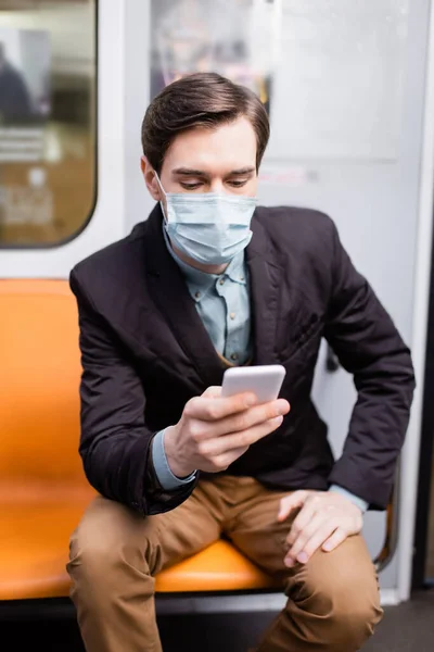 Homem Máscara Médica Usando Smartphone Enquanto Sentado Vagão Metrô — Fotografia de Stock