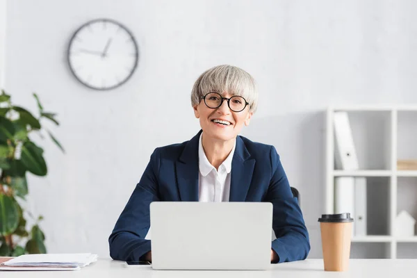 Alegre Líder Del Equipo Gafas Sonriendo Cerca Computadora Portátil Taza —  Fotos de Stock