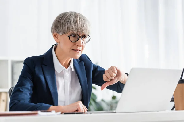 Medelålders Lagledare Glasögon Som Visar Tummen Ner Och Tittar Laptop — Stockfoto