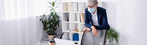 Modne Teamleder Briller Medicinsk Maske Stående Nærheden Arbejdspladsen Ser Laptop - Stock-foto