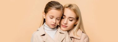 caring mother and daughter with closed eyes isolated on beige, banner clipart