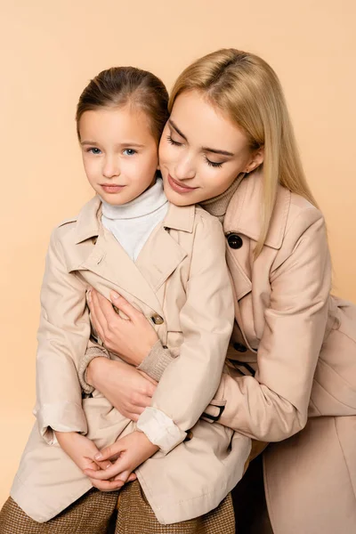 Madre Cariñosa Abrazando Hija Gabardina Aislada Beige —  Fotos de Stock