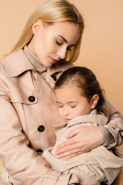 Blonde Mother Embracing Daughter Closed Eyes Isolated Beige — Stock Photo, Image