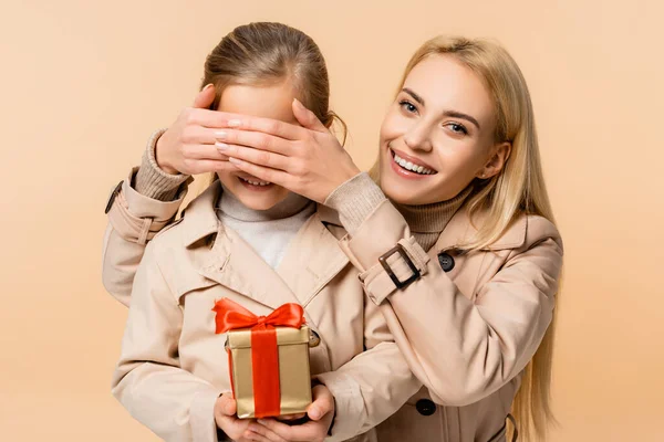 Happy Mother Covering Eyes Child Gift Box Isolated Beige — Stock Photo, Image