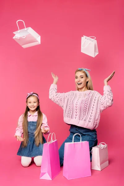 Étonné Mère Fille Souriant Près Des Sacs Provisions Sur Rose — Photo