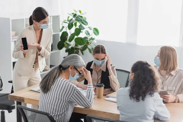 Teamleider Medisch Masker Wijzend Met Hand Smartphone Met Leeg Scherm — Stockfoto