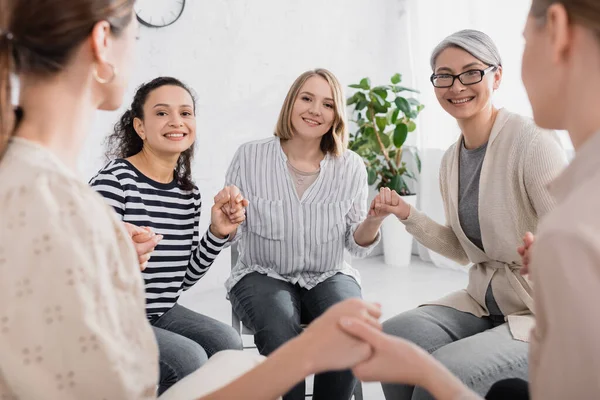 Fröhliche Multikulturelle Frauen Beim Händchenhalten Während Des Seminars — Stockfoto