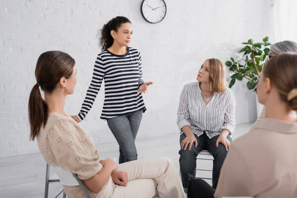 african american speaker talking with group of women during seminar