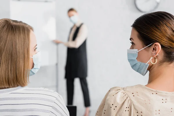 Junge Geschäftsfrauen Medizinischen Masken Betrachten Einander Während Eines Seminars — Stockfoto