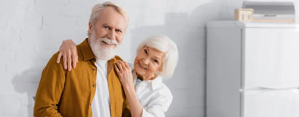 Usmívající Starší Žena Objímající Manžela Kuchyni Banner — Stock fotografie