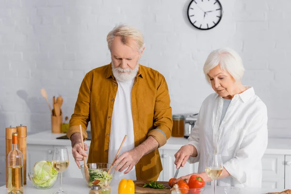 Casal Sênior Cozinhar Salada Perto Vinho Cozinha — Fotografia de Stock