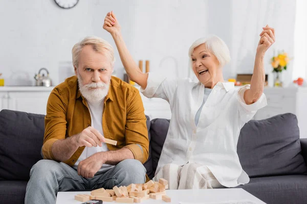 Excited Senior Woman Looking Husband Holding Part Blocks Wood Game — Stock Photo, Image