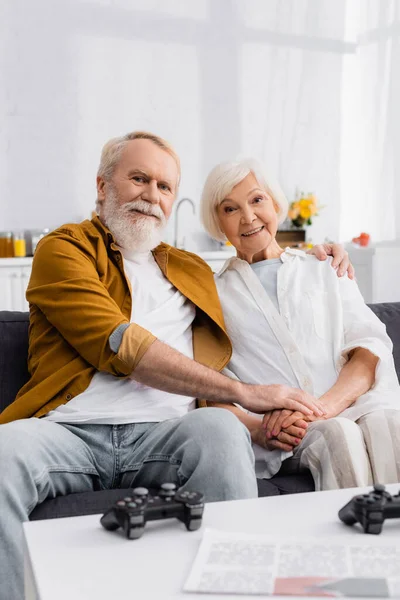 Kyiv Ukraine December 2020 Smiling Elderly Couple Hugging Couch Gamepads — Stock Photo, Image