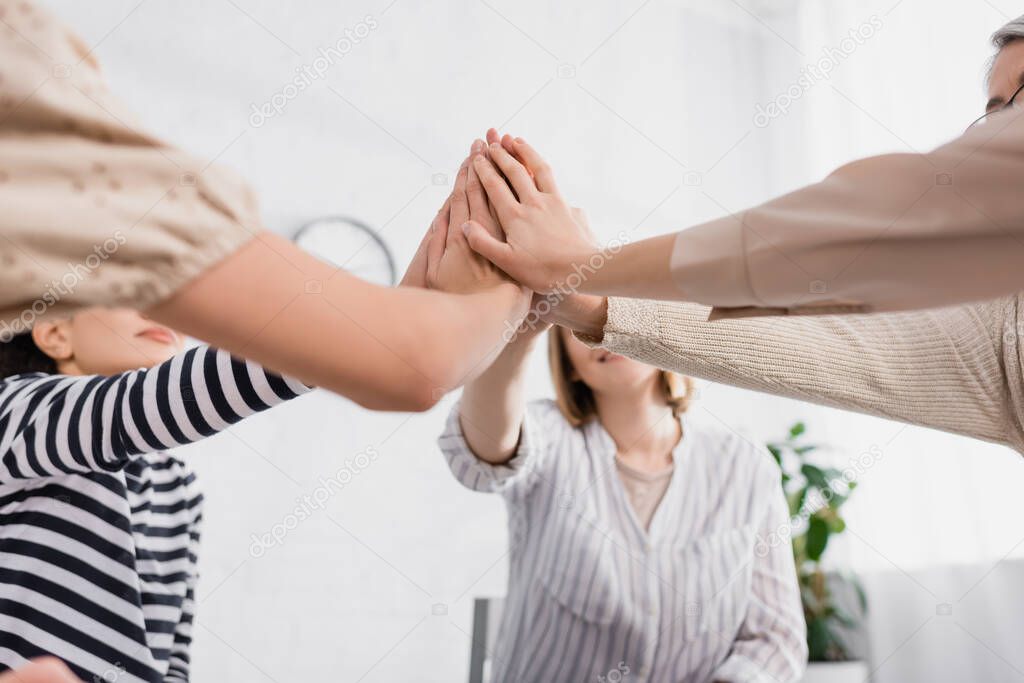 group of women holding hands together during seminar 