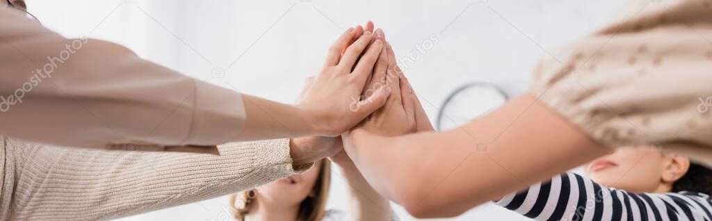group of women holding hands together during seminar, banner
