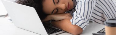Yorgun Afrikalı Amerikalı kadın evinde dizüstü bilgisayarda uyuyor.