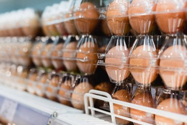 Bulanık arkaplanda süpermarketteki paketlerdeki yumurtaların görüntüsünü kapat 