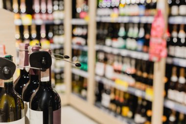 Bulanık arkaplanda süpermarketteki şarap şişelerinin görüntüsünü kapat 