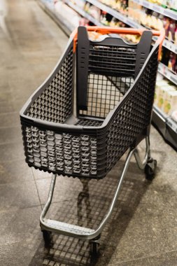 Bulanık arkaplanda süpermarkette boş alışveriş arabası 