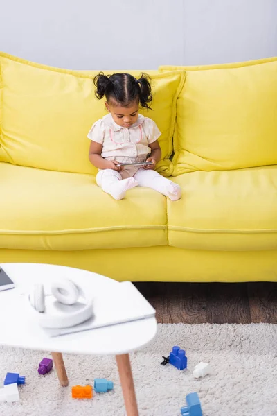 Niño Afroamericano Niña Usando Teléfono Inteligente Mientras Está Sentado Sofá —  Fotos de Stock