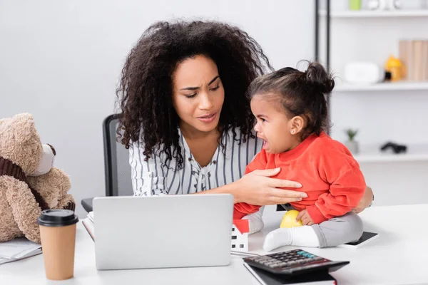 Curly African American Freelancer Supporting Toddler Daughter Sitting Desk Laptop — Stock Photo, Image
