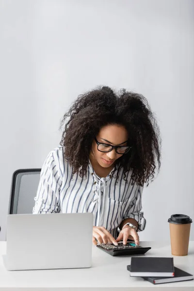 Freelancer Afroamericano Gafas Usando Calculadora Mientras Cuenta Cerca Laptop Taza — Foto de Stock